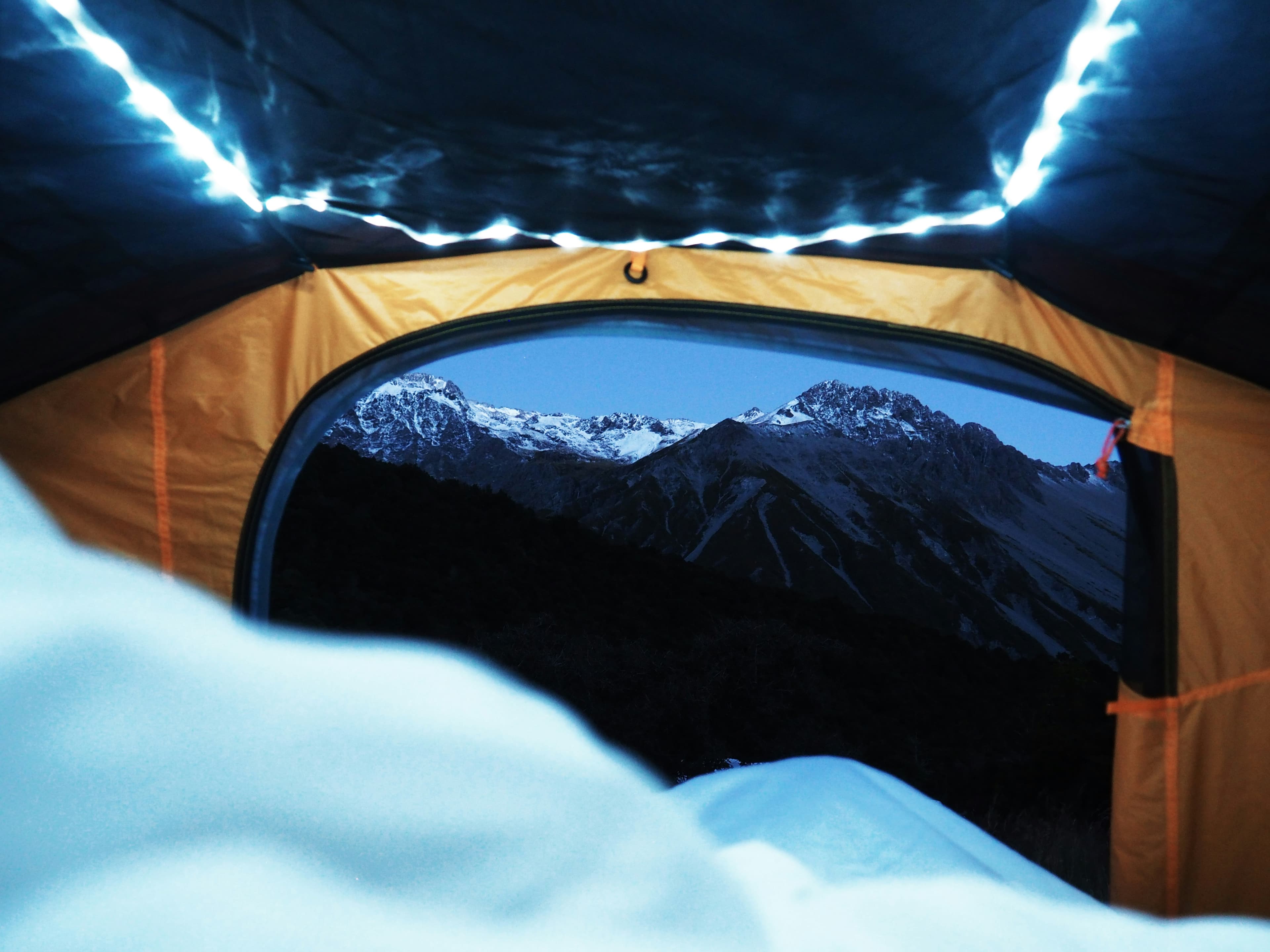 View from inside a tent looking out at a mountain